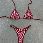 Red checkered bikini top and bottom laid flat on the floor.