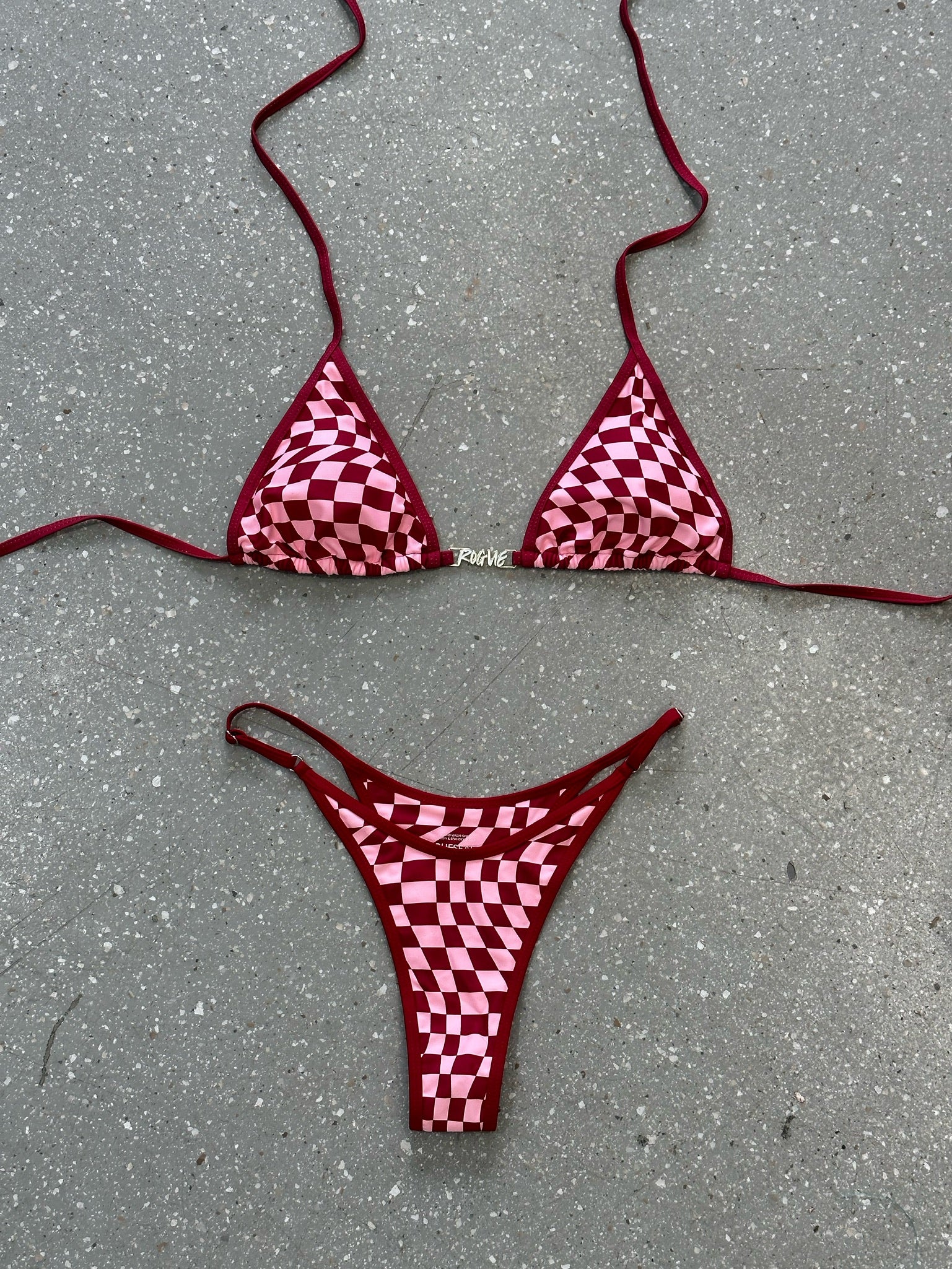 Red checkered bikini top and bottom laid flat on the floor.