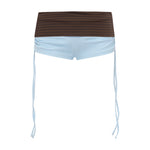 Blue bikini shorts with a brown gingham print waistband, featuring thin light blue side ties hanging down, shown against a plain white background.