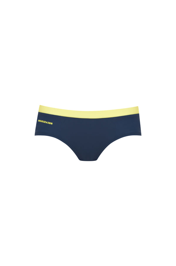 Low-rise bikini bottoms in navy with a yellow contrast waistband and a yellow logo, set on a white background.