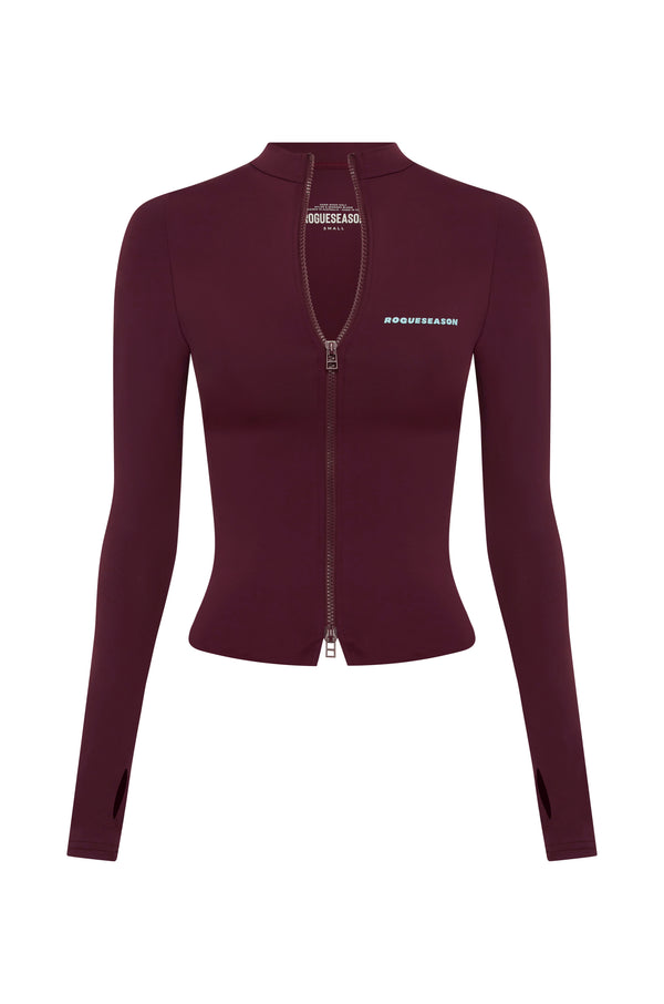 A long-sleeve, fitted zip-up jacket in deep burgundy, featuring a high mock neck, a front zipper, and blue text branding on the chest, displayed on a solid white background.